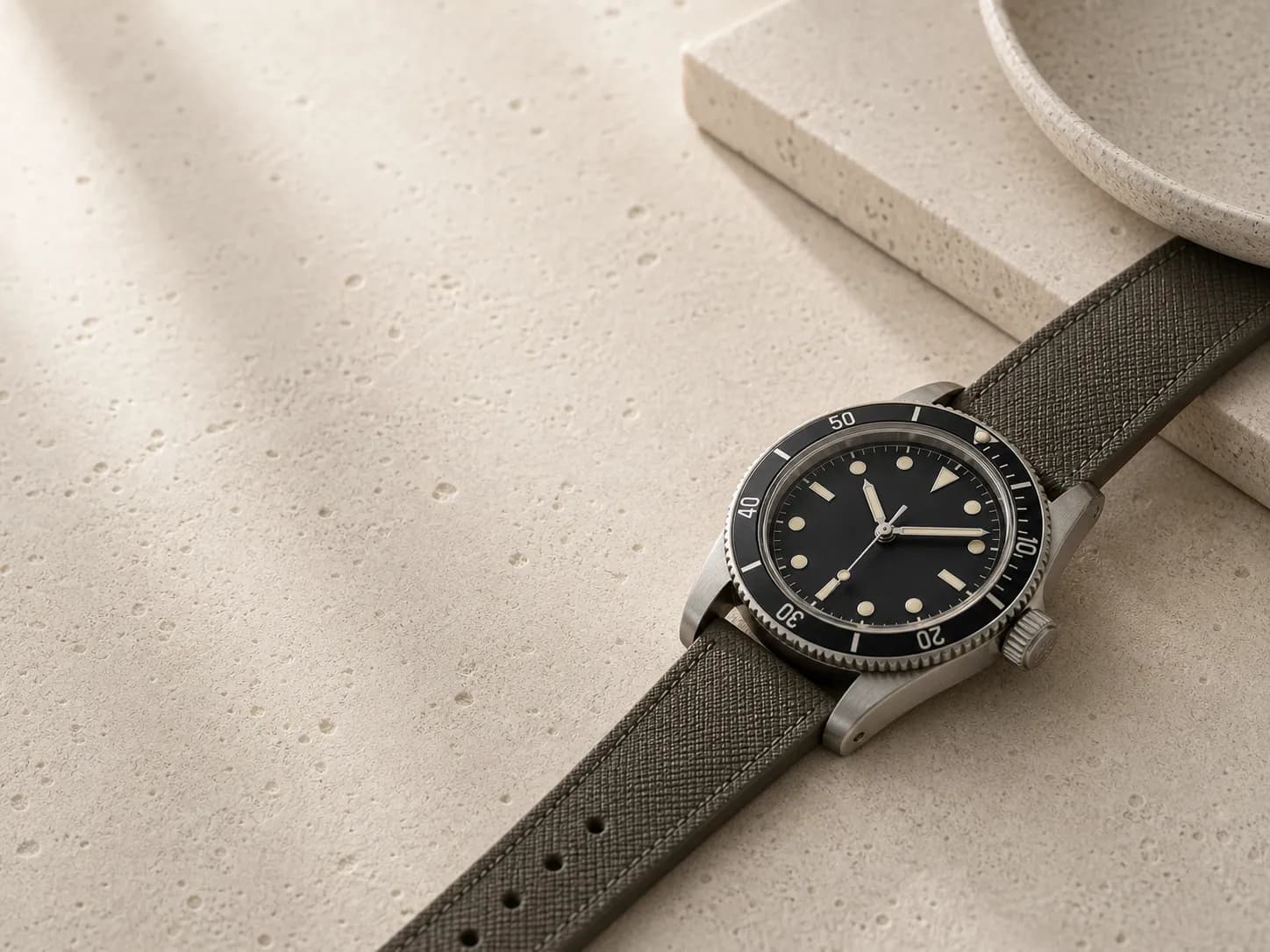 Unbranded dive-watch proportion on warm stone