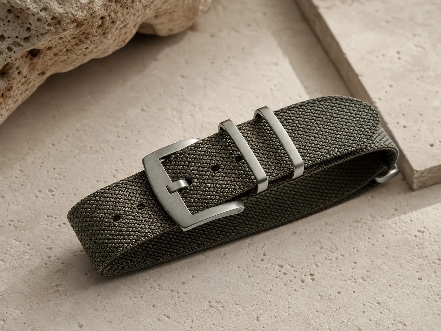 Fine nylon watch strap weave detail on a warm light surface